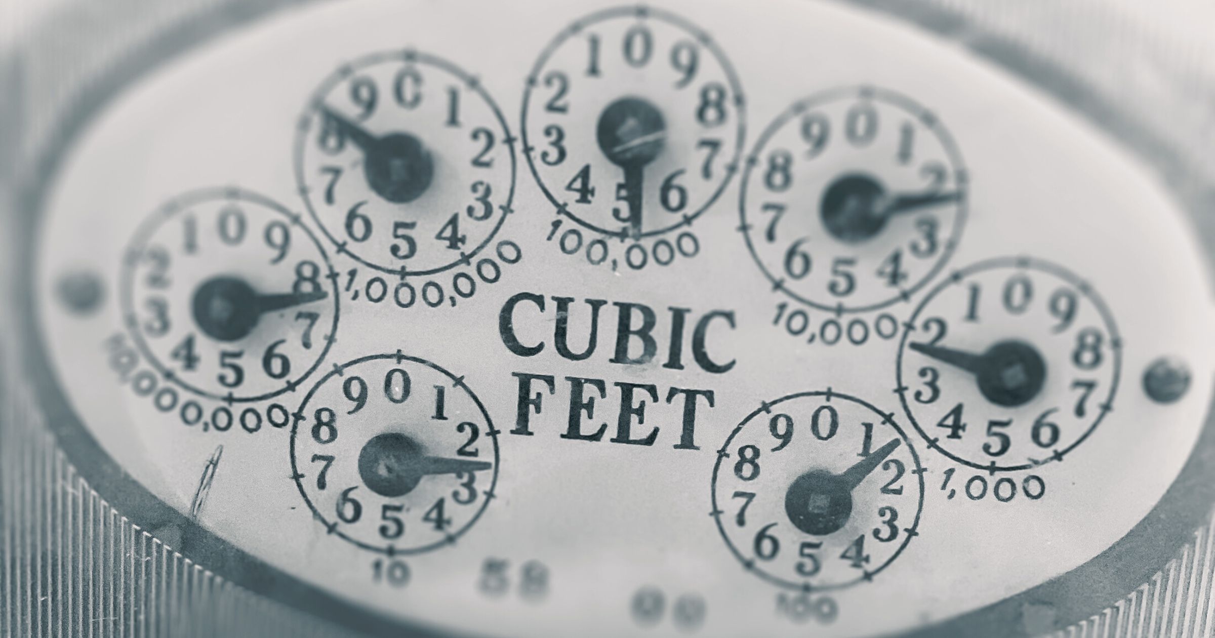 A close-up photograph of a dial meter showing cubic feet as the unit.